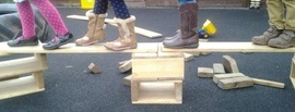 image of children's feet walking across planks