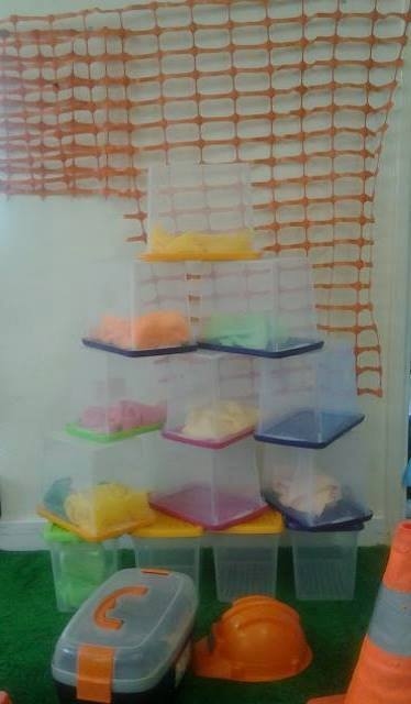 plastic containers stacked up and containing different items for children to play with